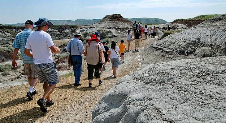 People walk on a badlands trail outside the Museum. 