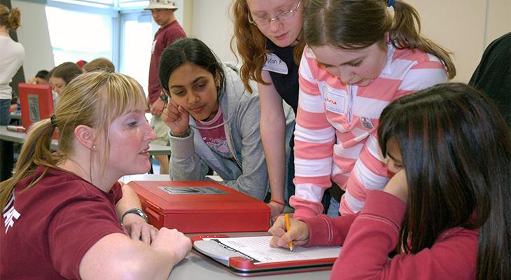 An educator speaks with a group of children. 